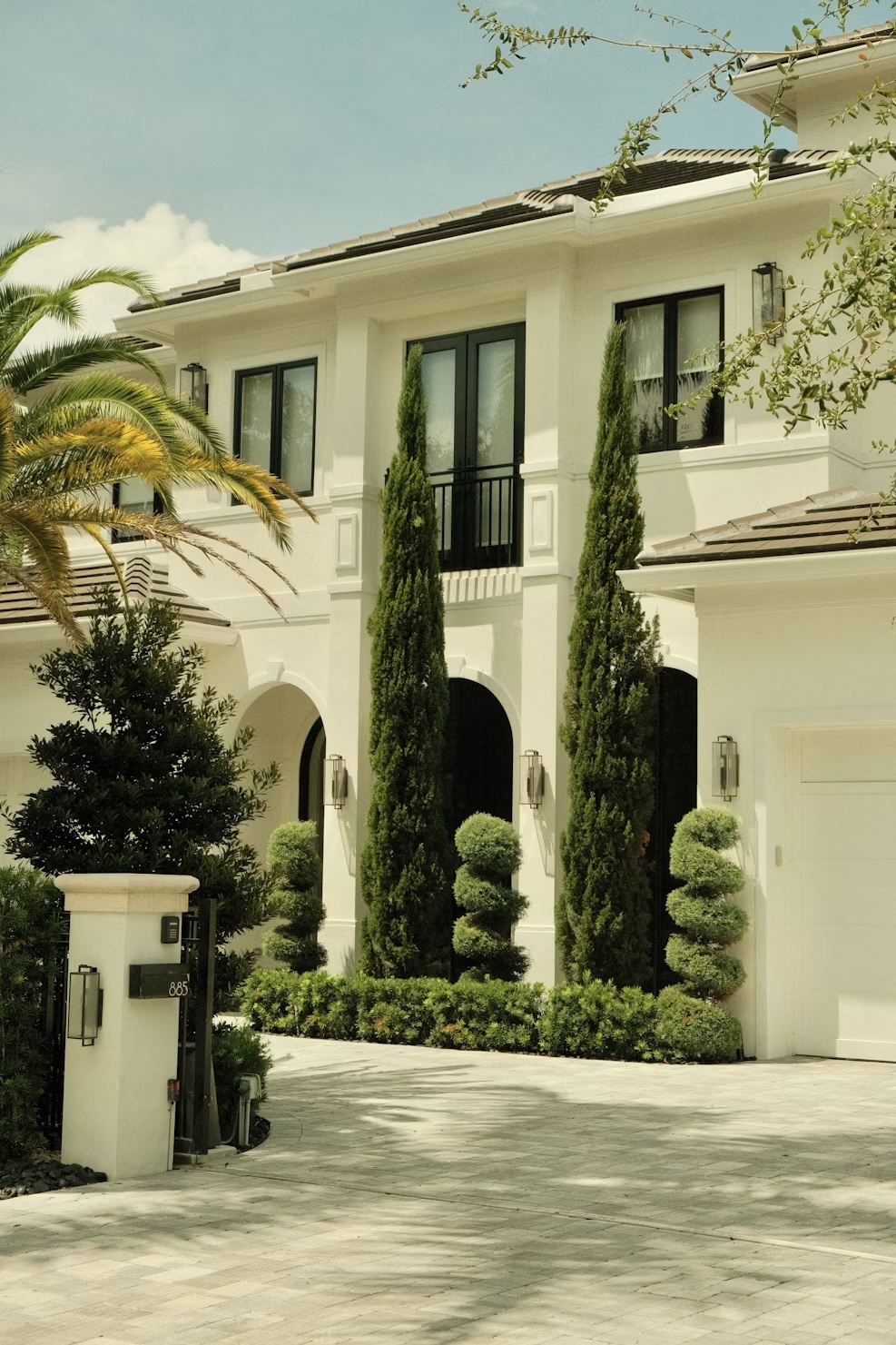 White luxury residential facade framed by palms