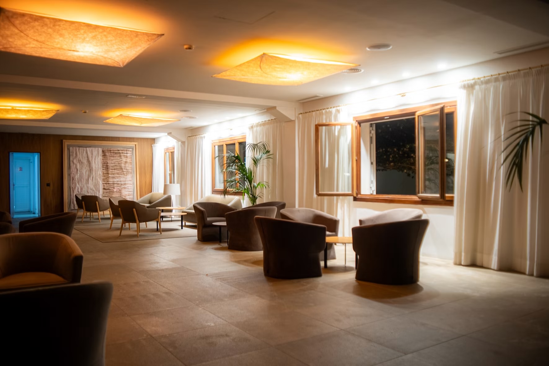 Warm boutique hotel lounge with low chairs and glowing ceiling lights
