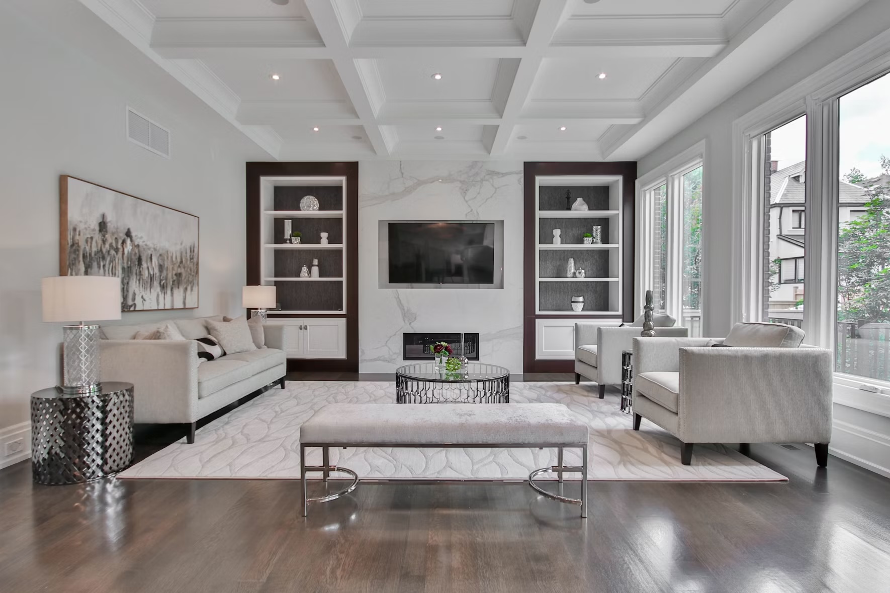 Elegant living room with coffered ceiling and marble fireplace wall