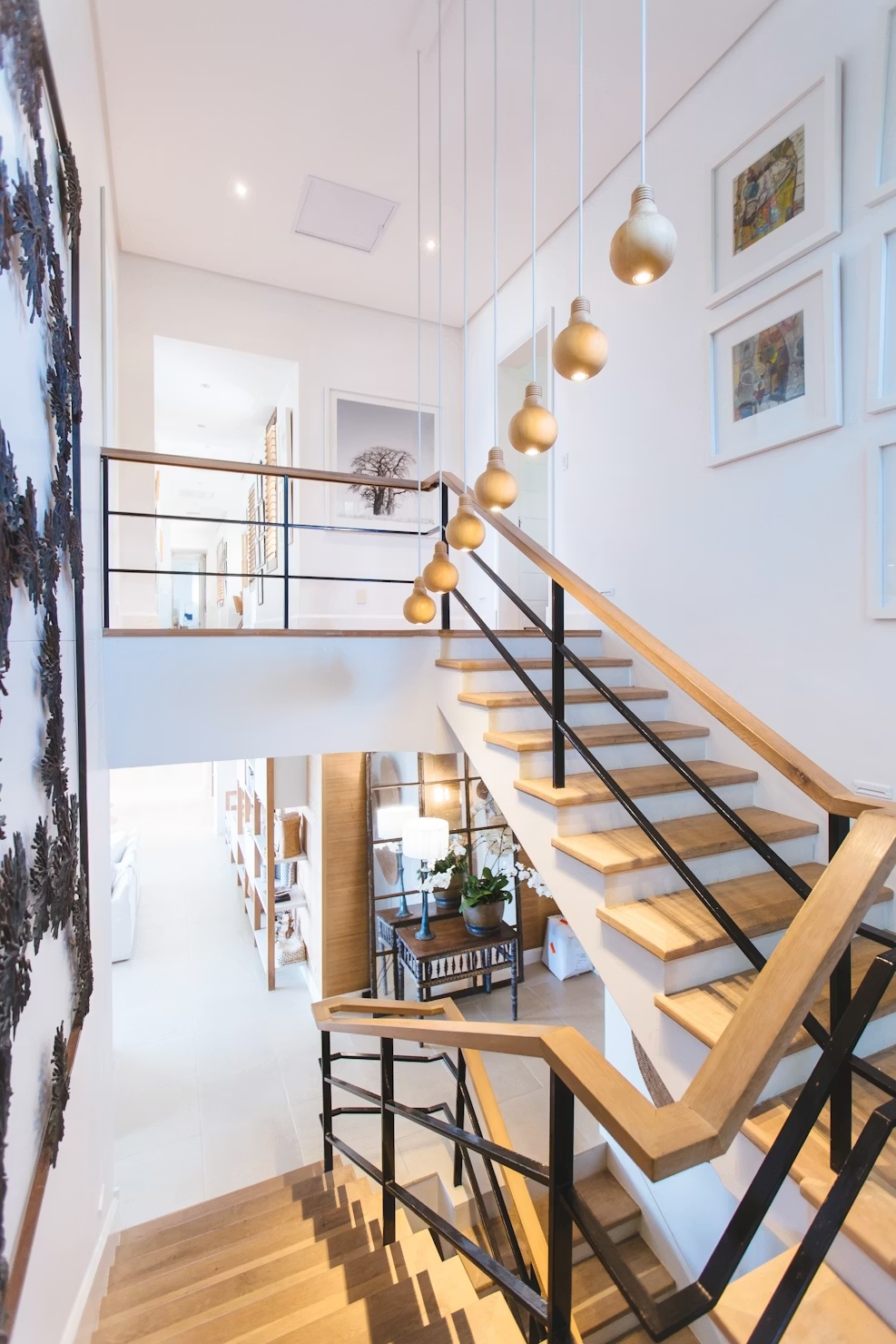 Tall residential stairwell with suspended globe lights